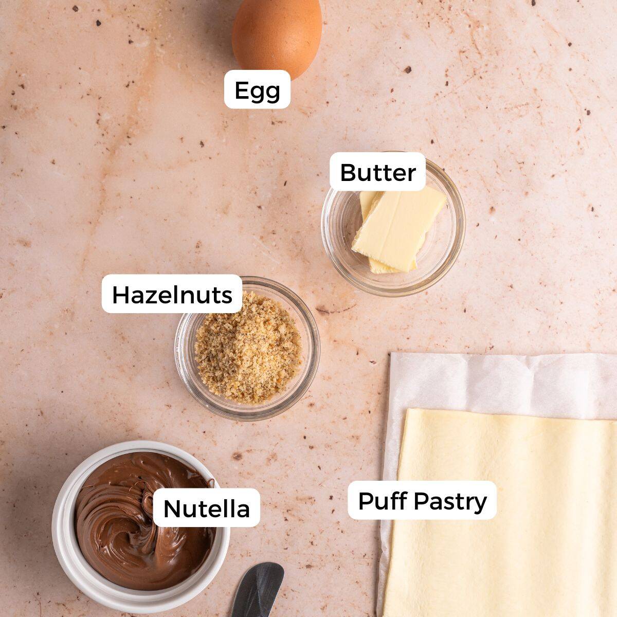 Ingredients include puff pastry, Nutella, hazelnuts, butter, and egg.