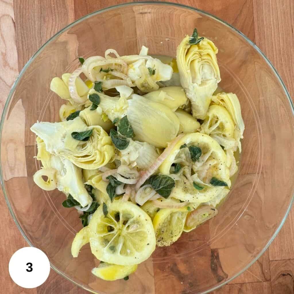 The sauce is poured over the artichoke hearts and they are left to marinate.