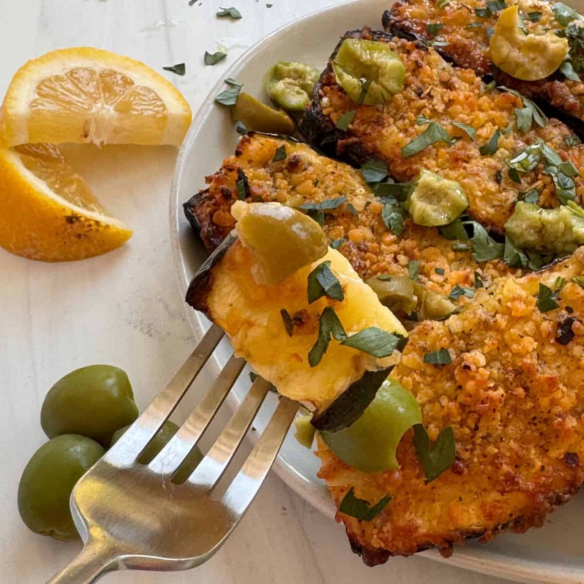 Holding a piece of the zucchini on a fork.