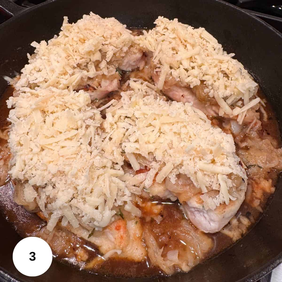 Topping the chicken with the onions and cheese. 