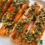 Moroccan salmon on a plate with a pistachio-mint gremolata on top.
