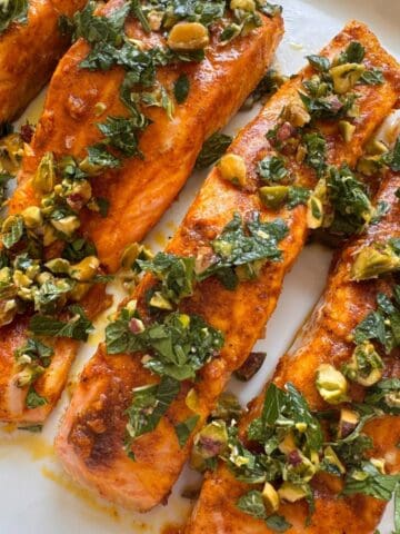 Moroccan salmon on a plate with a pistachio-mint gremolata on top.