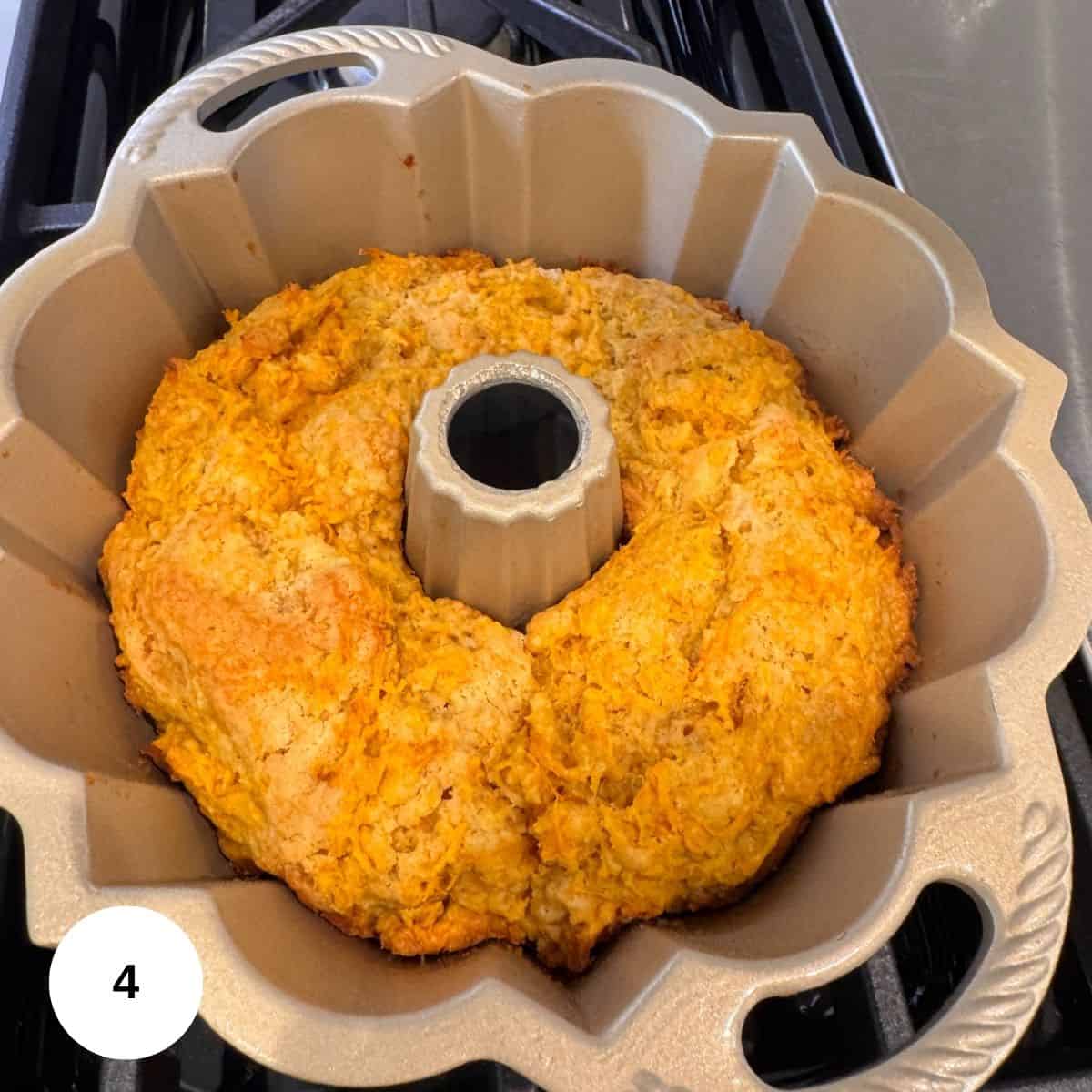 A golden-brown carrot ring bundt cake with a slightly rough texture sits in a Bundt pan on a stovetop. The number 4 is displayed in a white circle in the bottom left corner of the image.