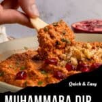 A hand dips a cracker into a bowl of muhammara dip, garnished with walnuts and pomegranate seeds. Text overlay reads: Quick & Easy Muhammara Recipe With Roasted Red Peppers & Walnuts.