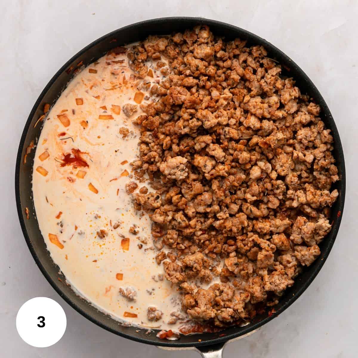 A skillet on a white surface contains cooked ground meat and onions on one side, and a creamy, reddish sauce for Italian Sausage Pasta on the other, starting to mix together. A white circle with the number 3 appears in the bottom left corner.