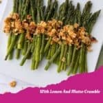 A plate of roasted asparagus with lemon and a golden matzo crumble, arranged neatly on a white square dish. Pink banner at the bottom reads: Roasted Asparagus with a small logo in the corner.