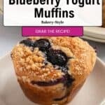 Bakery-style blueberry yogurt muffins topped with streusel sit on a plate, with more muffins in the background. Overlaid text reads: Quick & Easy Blueberry Yogurt Muffins. Bakery-Style. Grab the recipe!.
