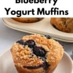 A close-up of delicious blueberry yogurt muffins with a crumb topping on a plate, more muffins in the background. Text above reads Bakery-Style Blueberry Yogurt Muffins.