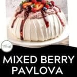 A large berry pavlova topped with whipped cream and assorted berries—strawberries, raspberries, and blueberries—sits on a white plate. Text reads: Mixed Berry Pavlova, gluten-free, download now.