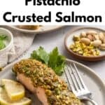 A plate with pistachio crusted salmon, garnished with fresh parsley and lemon slices. A fork rests on the plate. In the background, a small dish of pistachios and herbs is visible. Text describes this delicious dish.