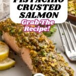 Close-up of pistachio crusted salmon fillet, topped with a golden nutty layer and garnished with herbs and lemon slices. Bold text overlay reads: “Pistachio Crusted Salmon. Grab the recipe! With Za’atar & Lemon.”.