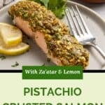 A plate with pistachio crusted salmon garnished with parsley, two lemon slices, and a fork beside it. Text reads: With Za’atar & Lemon, Pistachio Crusted Salmon. Crushed pistachios are visible in the background.