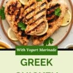 Grilled chicken breasts with grill marks, garnished with lemon slices and parsley on a plate. Text on image reads: Greek chicken with yogurt marinade.