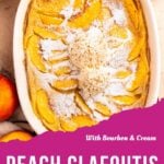 A peach clafoutis baked to perfection, dusted with powdered sugar and crowned with two scoops of ice cream in a white dish, surrounded by fresh peach slices. Text reads: With Bourbon & Cream Peach Clafoutis.
