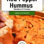 A hand dips pita bread into a bowl of Roasted Red Bell Pepper Hummus, garnished with chickpeas and herbs. The text reads: Quick & Easy Creamy Hummus, Smoky & Creamy. Grab the recipe!.