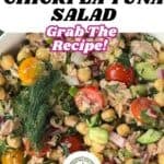 A vibrant bowl of chickpea tuna salad featuring juicy tomatoes, crisp cucumbers, and a medley of fresh herbs, highlighting a deliciously satisfying mayo-free recipe.