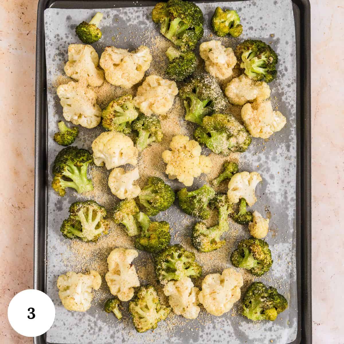 A baking sheet lined with parchment paper holds raw roasted broccoli and cauliflower florets sprinkled with seasoning, ready to be roasted. A white circle with the number 3 is in the lower left corner.