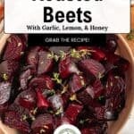 A bowl of roasted beetroot garnished with herbs, surrounded by a honey jar, peppercorns, and a napkin. Text overlay: Roasted Beets with Garlic, Lemon, & Honey—your new favorite way to enjoy roasted beets. Grab the recipe!.