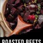 A wooden spoon scoops roasted beets from a bowl, garnished with fresh thyme. Text at the bottom reads Roasted Beets With Garlic, Lemon, & Honey, highlighting the vibrant flavors of perfectly roasted beets.