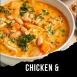 A bowl of creamy Chicken and White Bean Soup with kale, carrots, and herbs, placed on a table next to bread slices. Text on the image reads: Chicken & White Bean Soup With Kale. This comforting dish features tender braised chicken thighs for extra flavor and richness.