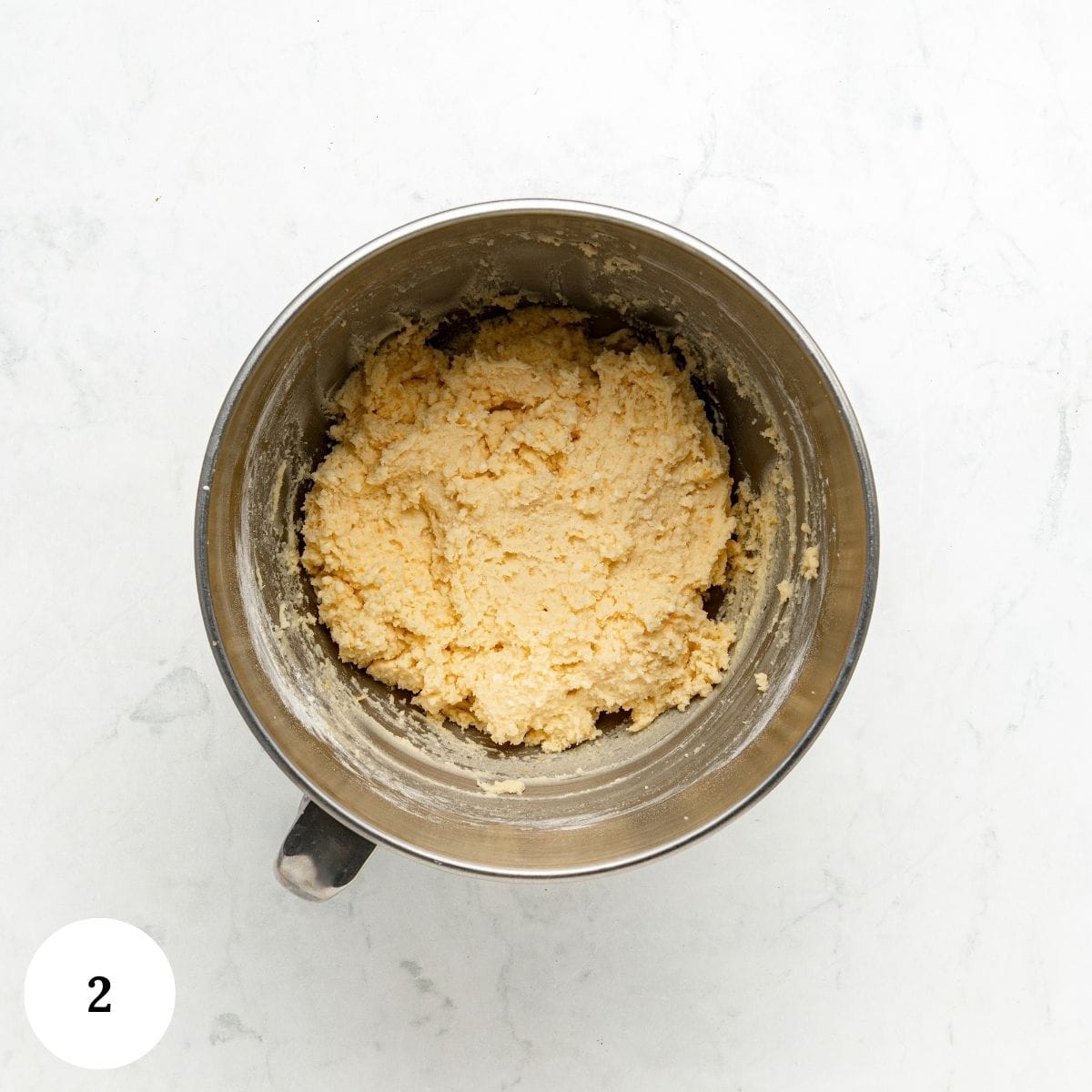 Lemon ricotta cookie dough mixed in a stainless steel mixing bowl.
