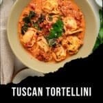 A bowl of creamy Tuscan Tortellini Soup with sausage and spinach topped with fresh herbs, with text overlay reading Tuscan Tortellini Soup with Sausage and Spinach.
