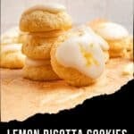 A stack of lemon ricotta cookies topped with white glaze and lemon zest on parchment paper.